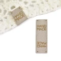 114329.webpZestaw metek ekoskóra metalizowana "HAND MADE" / beż / 60 x 20 mm / 5 szt.