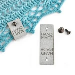 Metka nubuk premium z nitem "HAND MADE" / jasny szary / 60 x 20 mm / 1 szt.