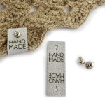 Metka ekoskóra metalizowana z nitem "HAND MADE" / srebrny / 60 x 20 mm / 1 szt.