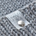 Metka silikonowa z nitem do czapki "HAND MADE" / srebro / 60 x 20 mm / 1 szt.