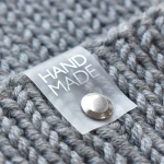Silikonová cedulka s nýtem na čepici "HAND MADE" / stříbro / 60 x 20 mm / 1 ks.
