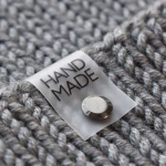 Silikonová cedulka s nýtem na čepici "HAND MADE" / černá / 60 x 20 mm / 1 ks.
