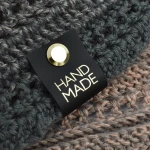 Metka silikonowa czarna z nitem "HAND MADE" / złoto / 60 x 20 mm / 1 szt.